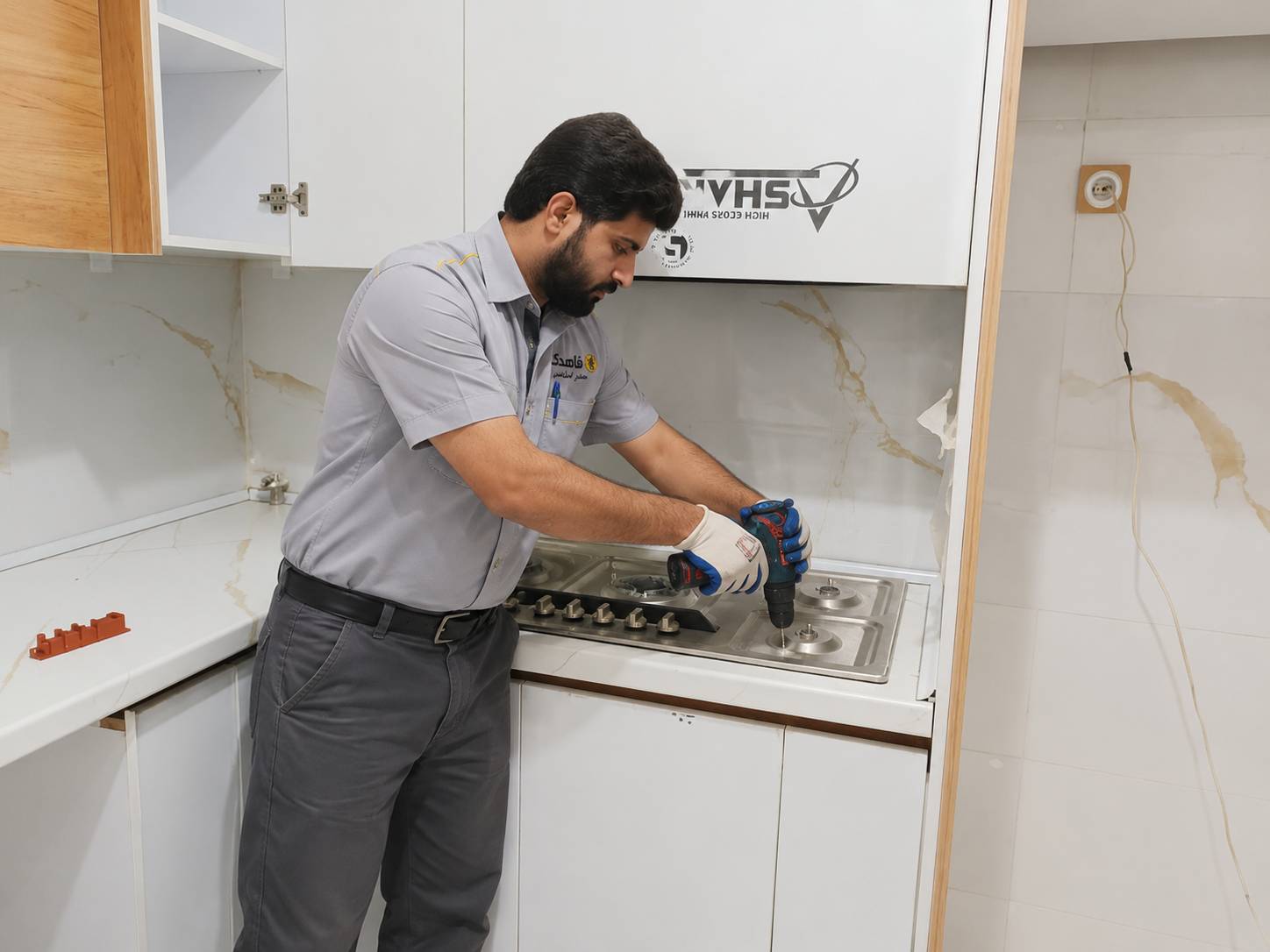 تعمیرکار درحال تعمیر اجاق گاز